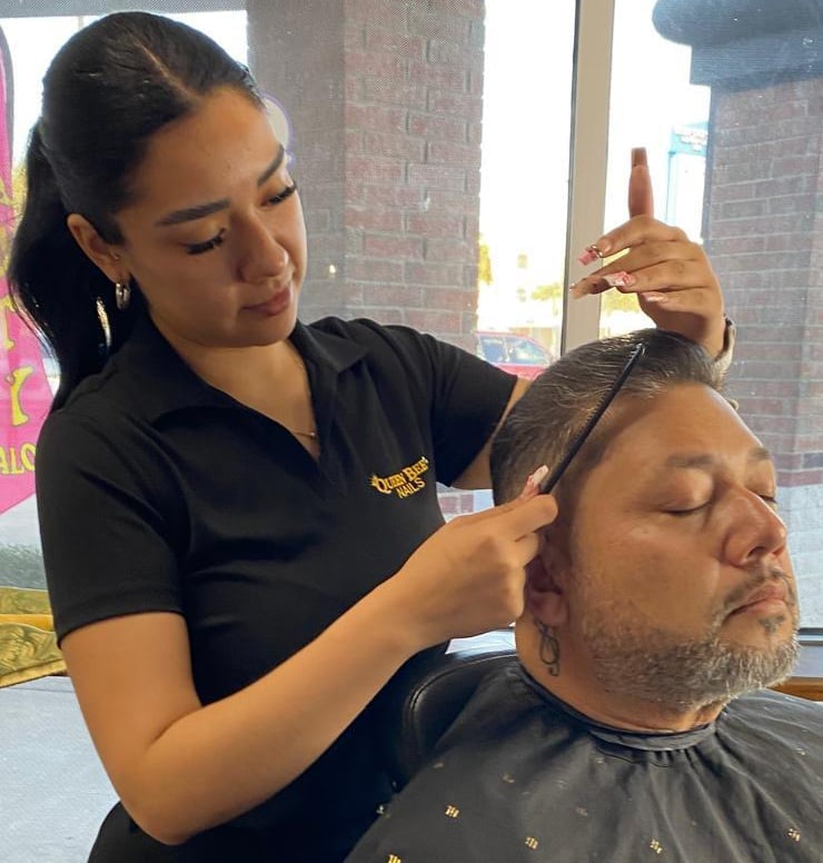 Barber cutting a male customers hair in a salon, using clippers and comb on his short hair